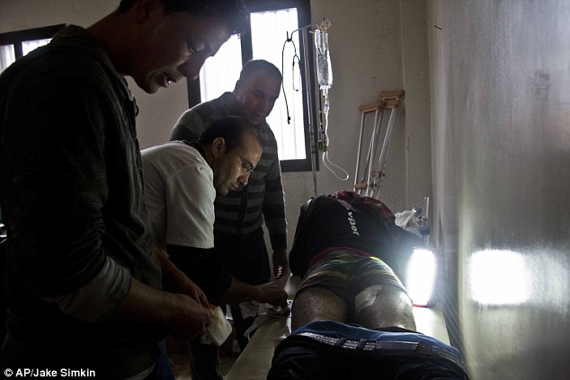 Dr. Mohammed Arif helps to deal with a wounded patient at a field hospital in Kobane