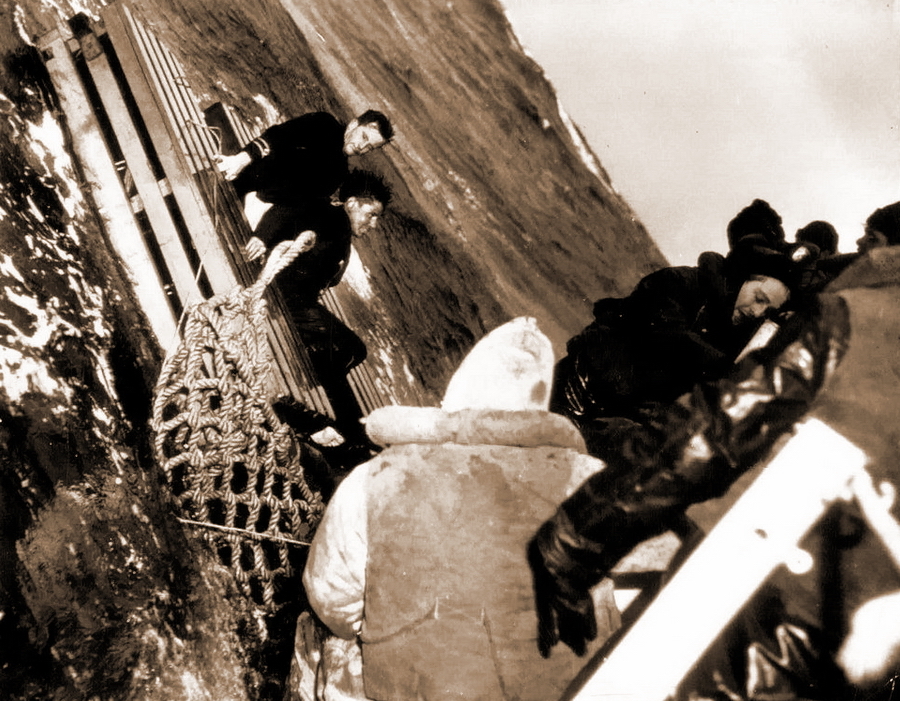 ​Драматичное фото, сделанное 11 мая 1943 года. Корабль береговой охраны США в неспокойном море поднимает моряков торпедированного британского судна со спасательного плота - Победившие смерть 